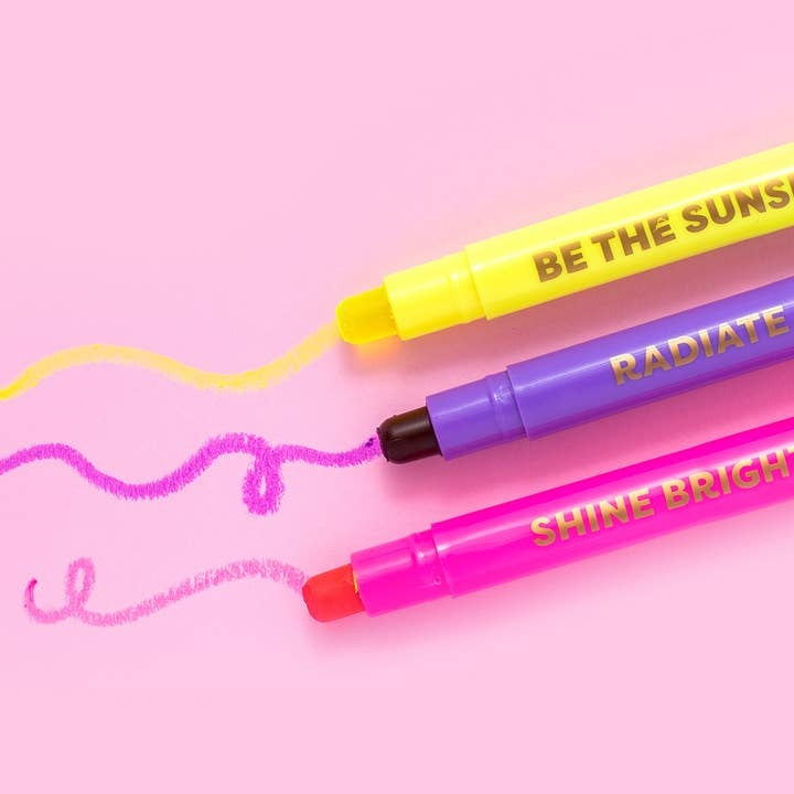 Six colorful wax highlighters in yellow, purple, pink, orange, green, and blue with motivational phrases inside a gold foil star box.