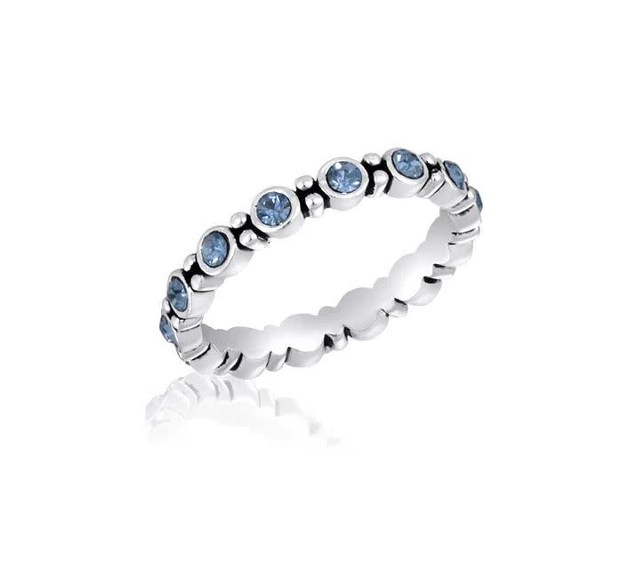 Blue cubic zirconia round stack ring with a polished metal band.