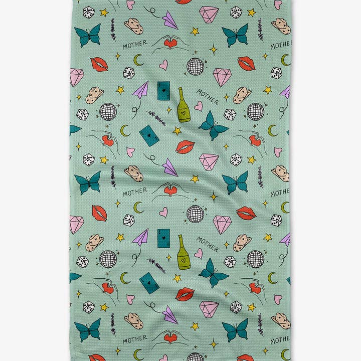 Light green waffle weave tea towel with a pattern of butterflies, lips, dice, and 'Mother' text.