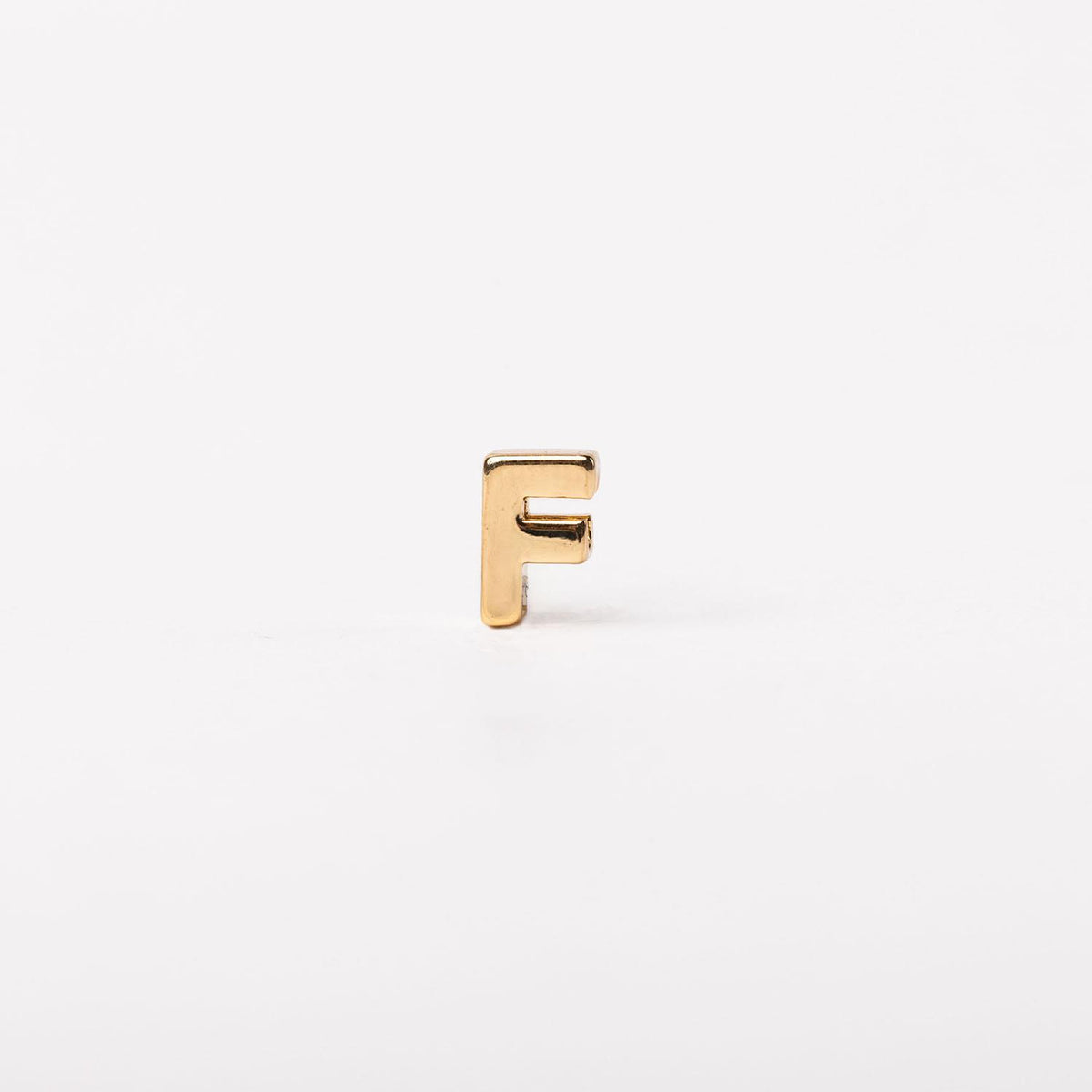 Gold-toned letter F charm with a polished, minimalist block silhouette.