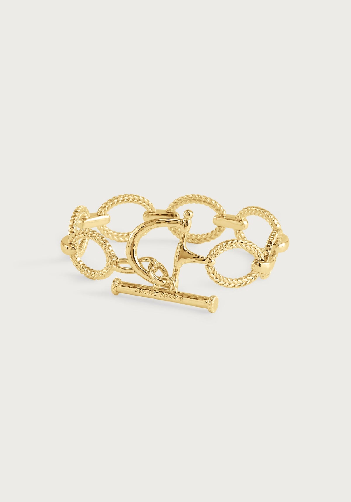Gold Cheval Chain Bracelet featuring braided links and an equestrian horse bit toggle clasp.