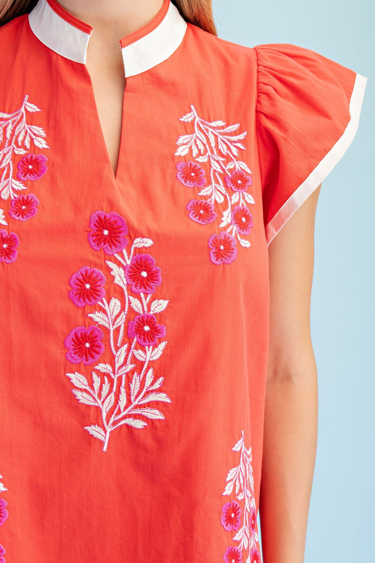 Floral embroidered cotton V-neck top with contrasting stripe trim on flutter sleeves.