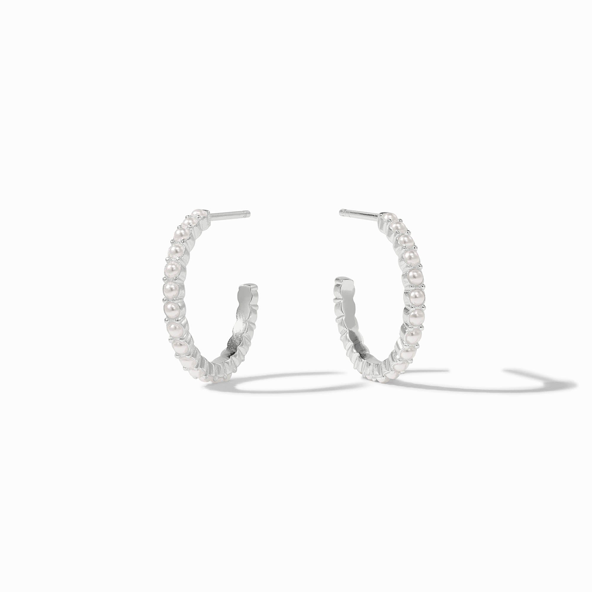 Juliet silver hoop earrings featuring a row of small white glass pearls on a silver-plated band.