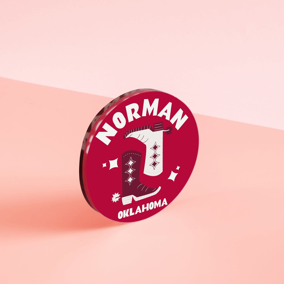 Four-inch acrylic Kickoff Coasters Norman in solid black with white text.