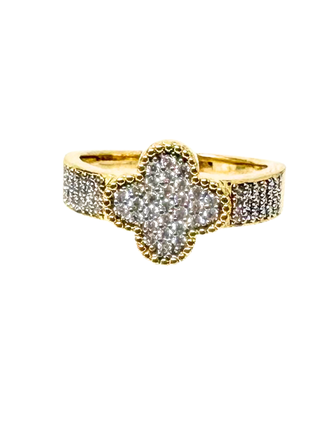 Gold fashion statement ring with a clover-shaped center and band encrusted with small crystals.