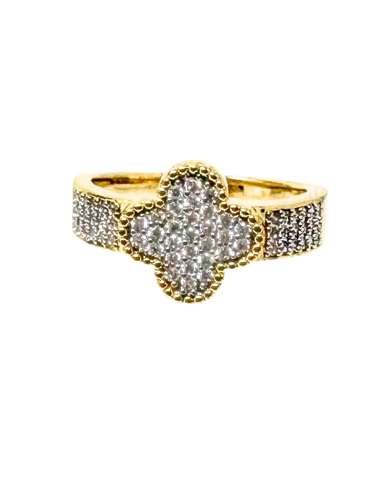 Gold fashion statement ring with a clover-shaped center and band encrusted with small crystals.