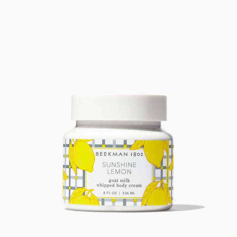 Whipped body cream jar with a sunshine yellow lid against a white background.