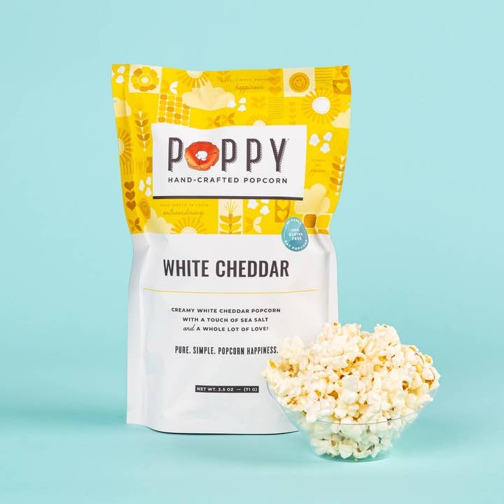 White cheddar popcorn in a clear bag showing white kernels with yellow cheese powder coating.