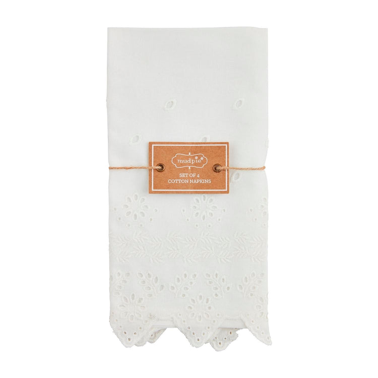 Set of four white cotton napkins with eyelet trim.
