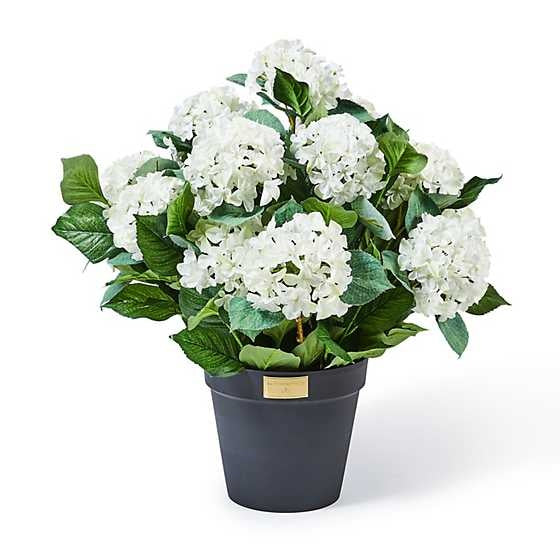 Black pot containing white artificial hydrangea filler with UV-protected florals.