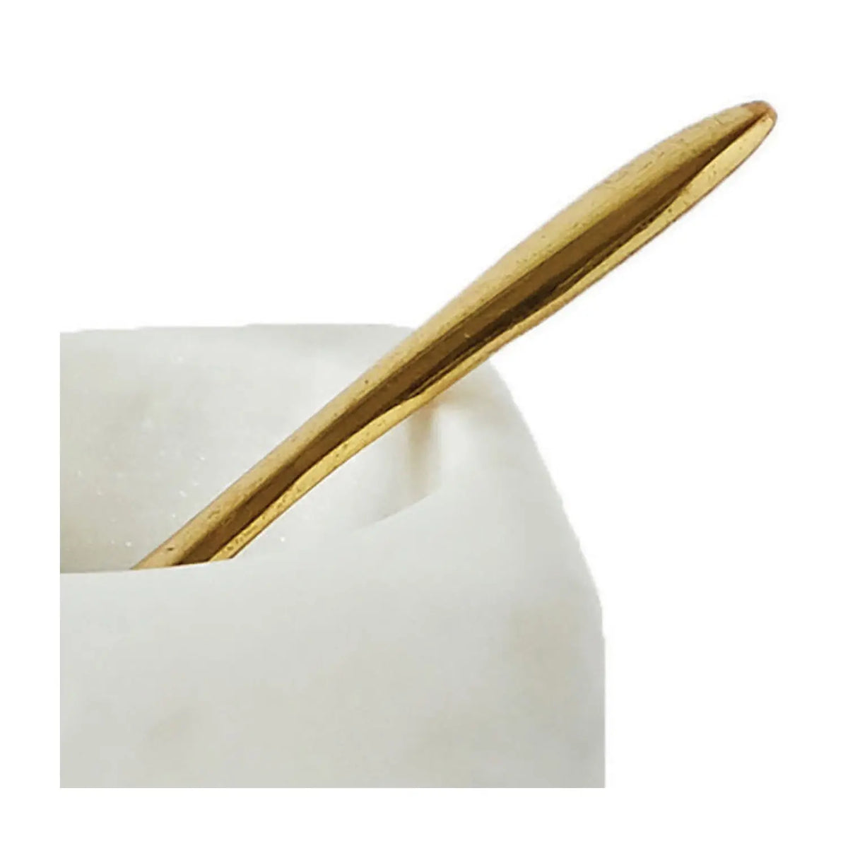 Square white marble bowl with round opening paired with a brass spoon