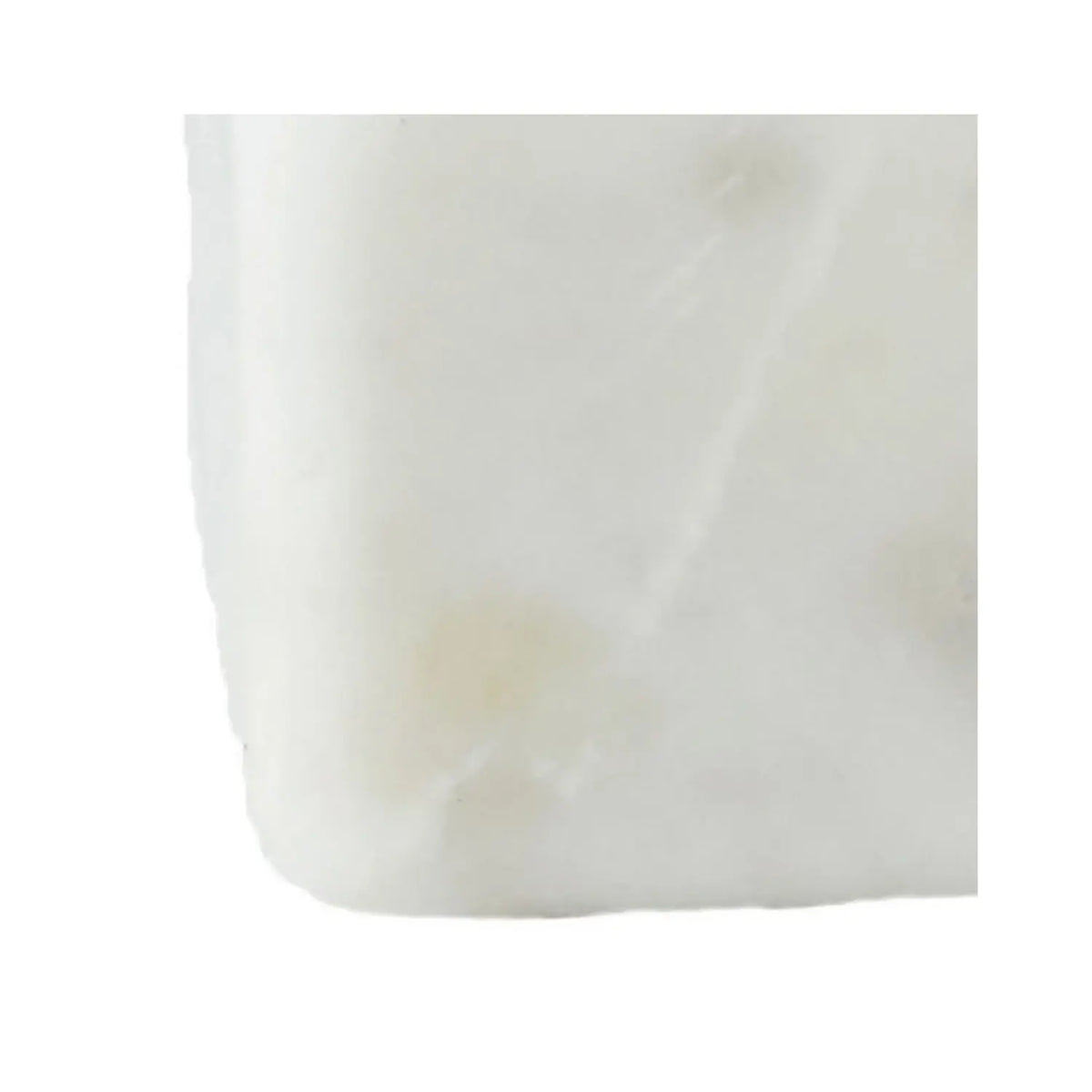 Square white marble bowl with round opening accompanied by a brass spoon