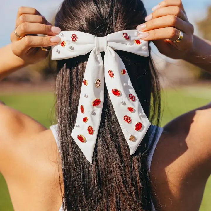 White bow barrette with gold University of Arkansas logo charms and hand-sewn resin pearls.