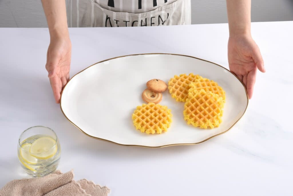 White oval porcelain tray with gold titanium rim accents