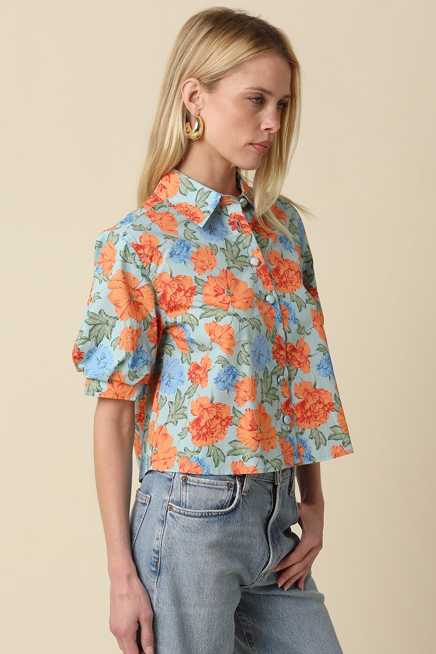 Mollie floral puff-sleeve button top in light blue with orange and blue flowers, paired with jeans.