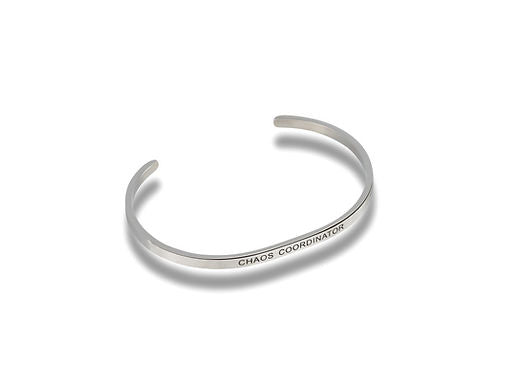 Silver-toned metal cuff bracelet engraved with the words CHAOS COORDINATOR.
