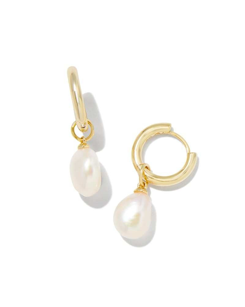 Gold huggie earrings featuring a white freshwater cultured pearl on an ear post.