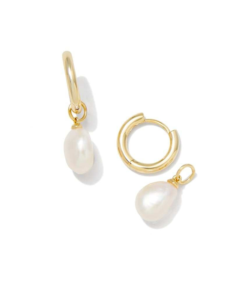 Gold huggie earrings featuring a white freshwater cultured pearl with an ear post closure.