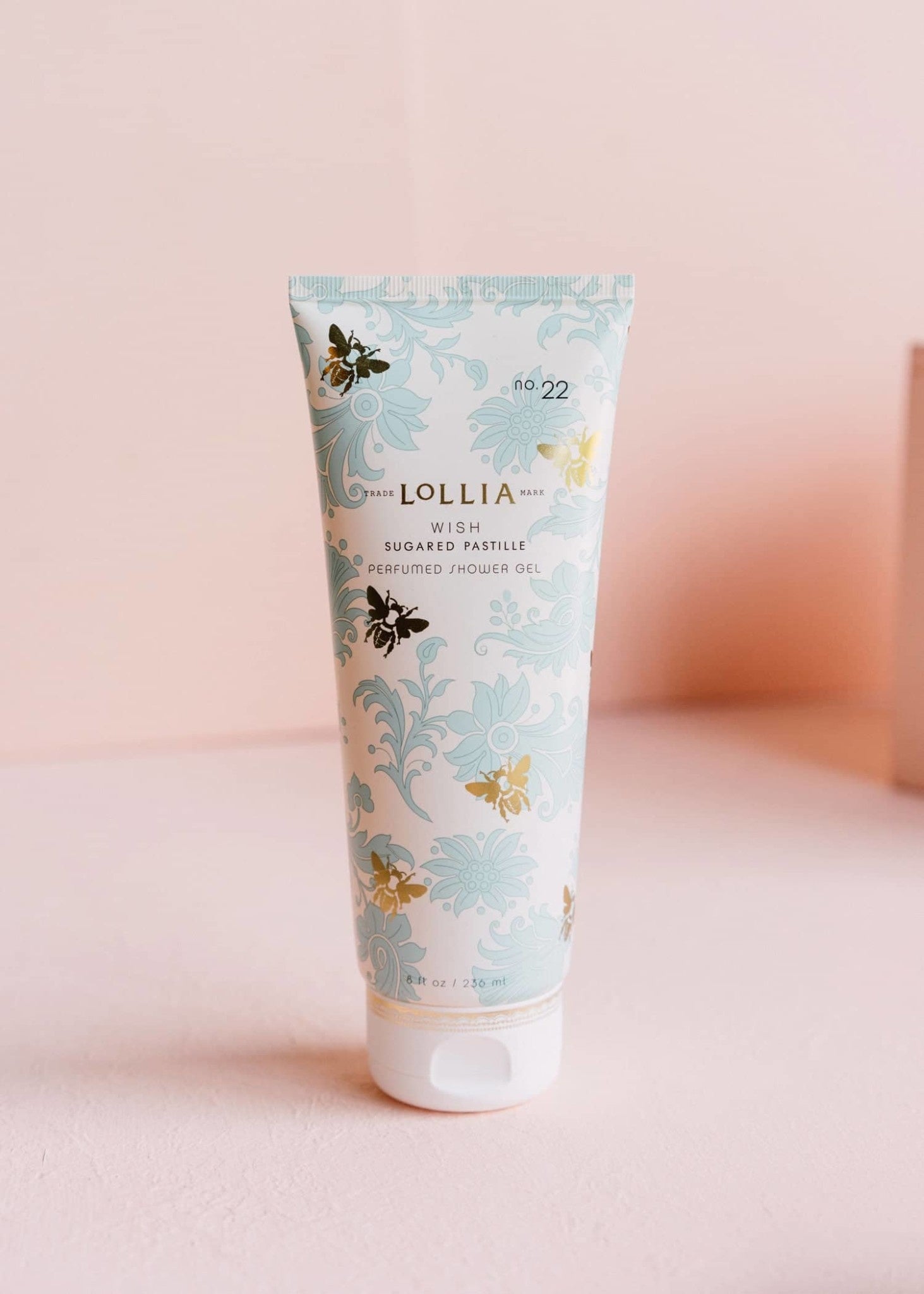 Blue French-inspired foulard tube with gold detailing containing Wish Perfumed Shower Gel.