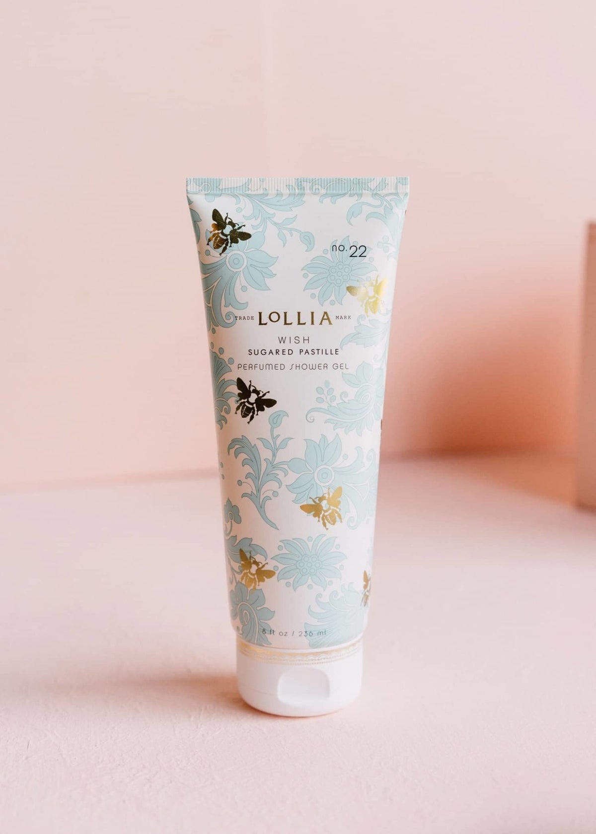 Blue French-inspired foulard tube with gold detailing containing Wish Perfumed Shower Gel.