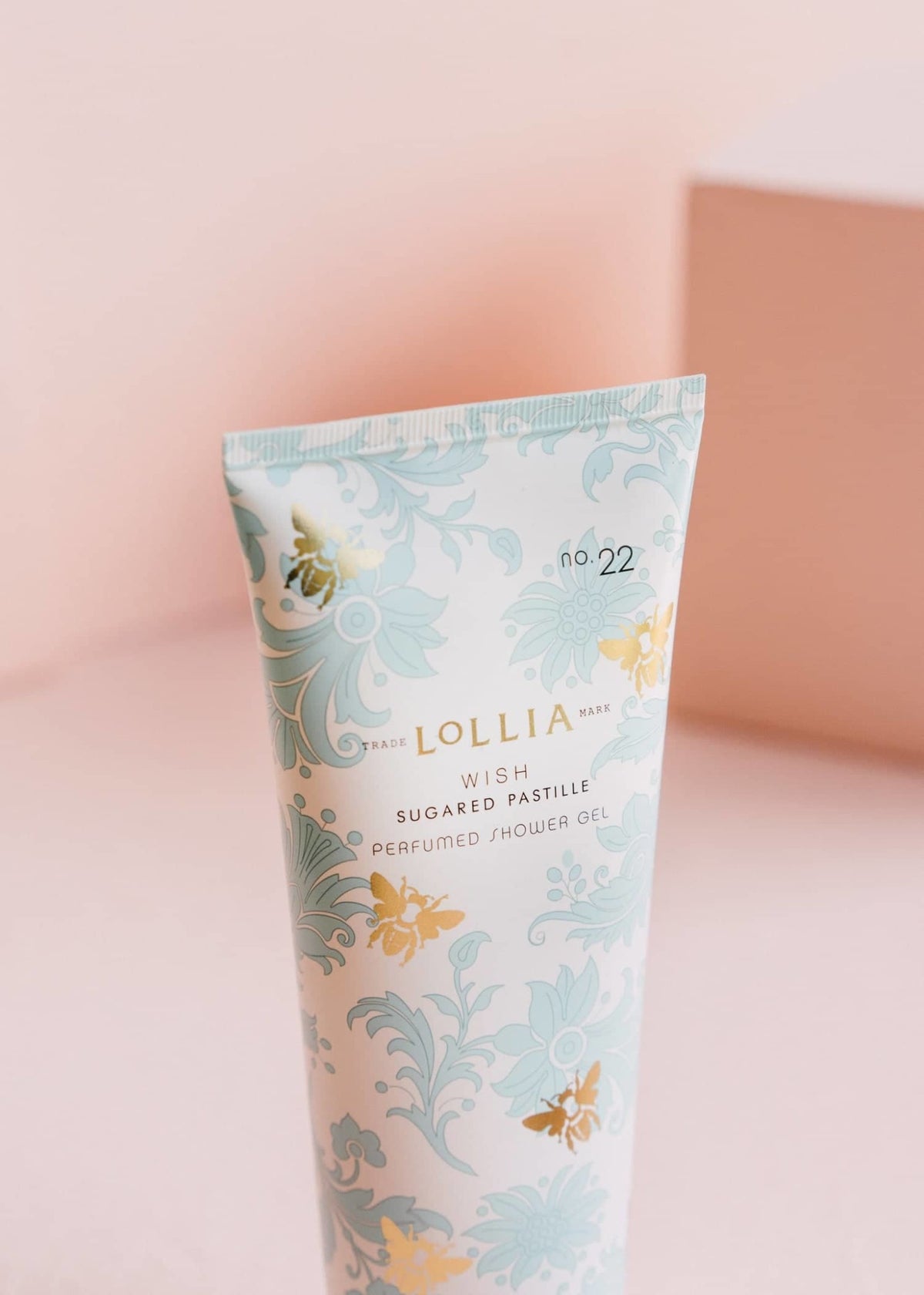 Blue French-inspired foulard tube with gold detailing containing Wish Perfumed Shower Gel.