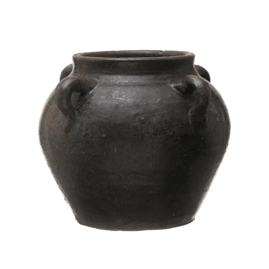 Found decorative clay jar in a dark charcoal finish with four small handles around the rim.