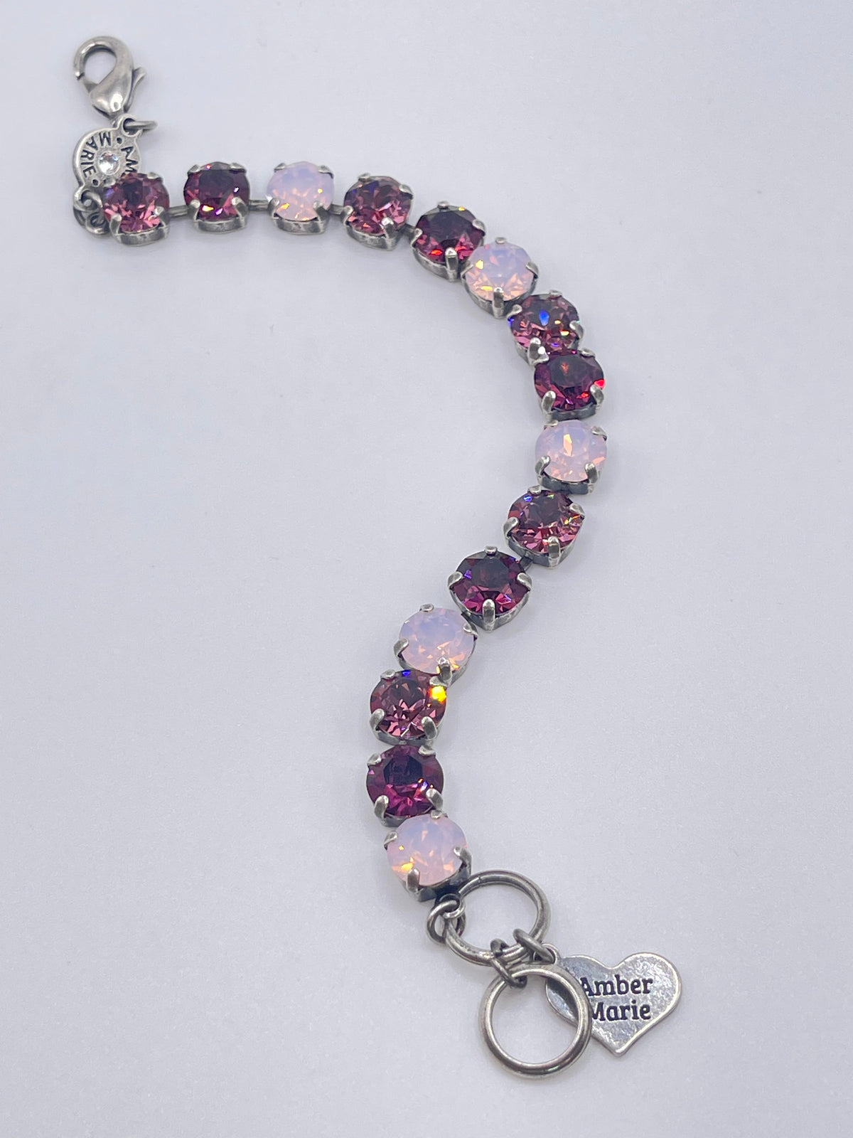 Milan bracelet featuring alternating pink and purple crystals on a silver chain with heart charm.