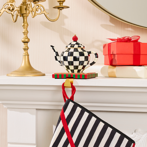 Courtly Check teapot stocking holder on a white mantel with a striped stocking hanging below.