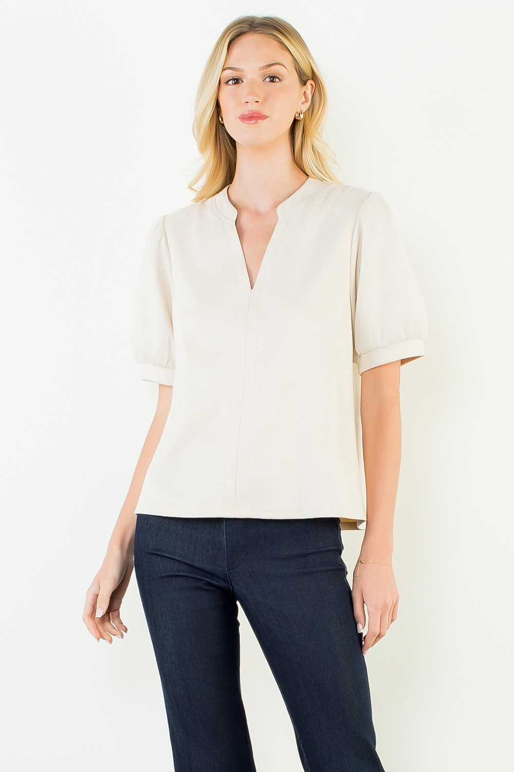 Woman wearing the Juliana Soft Suede V-Neck Top in cream with dark denim jeans.