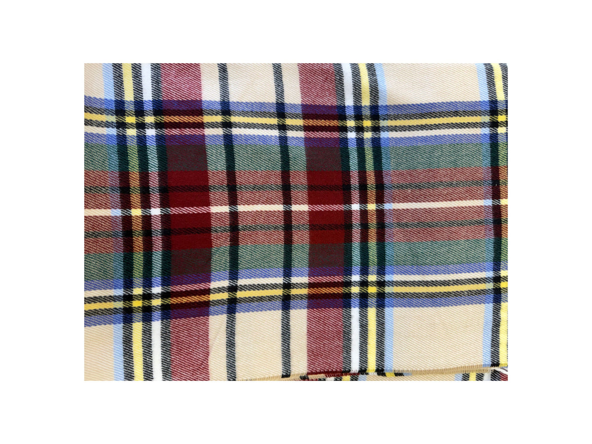 Close-up of a Scottish plaid cashmere scarf in beige, red, blue, and yellow tartan pattern.