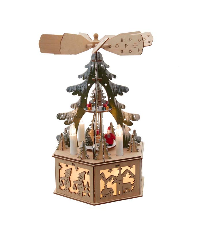 Tan plywood windmill with star cutout base featuring snowy trees and presents illuminated by warm white LEDs