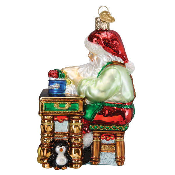 Side view of a red Workshop Santa ornament with white beard working at an anvil.