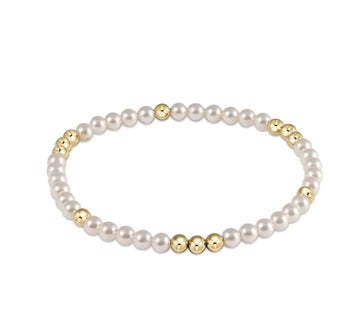 Pearl beaded bracelet with gold accents on elastic cord