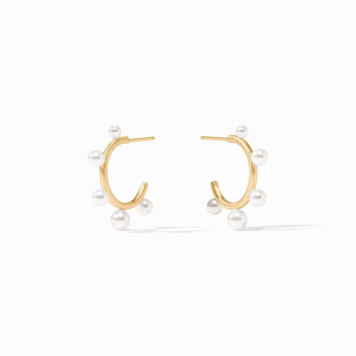 Slender golden hoop earrings with small shell pearls and gumdrop-like gemstones.