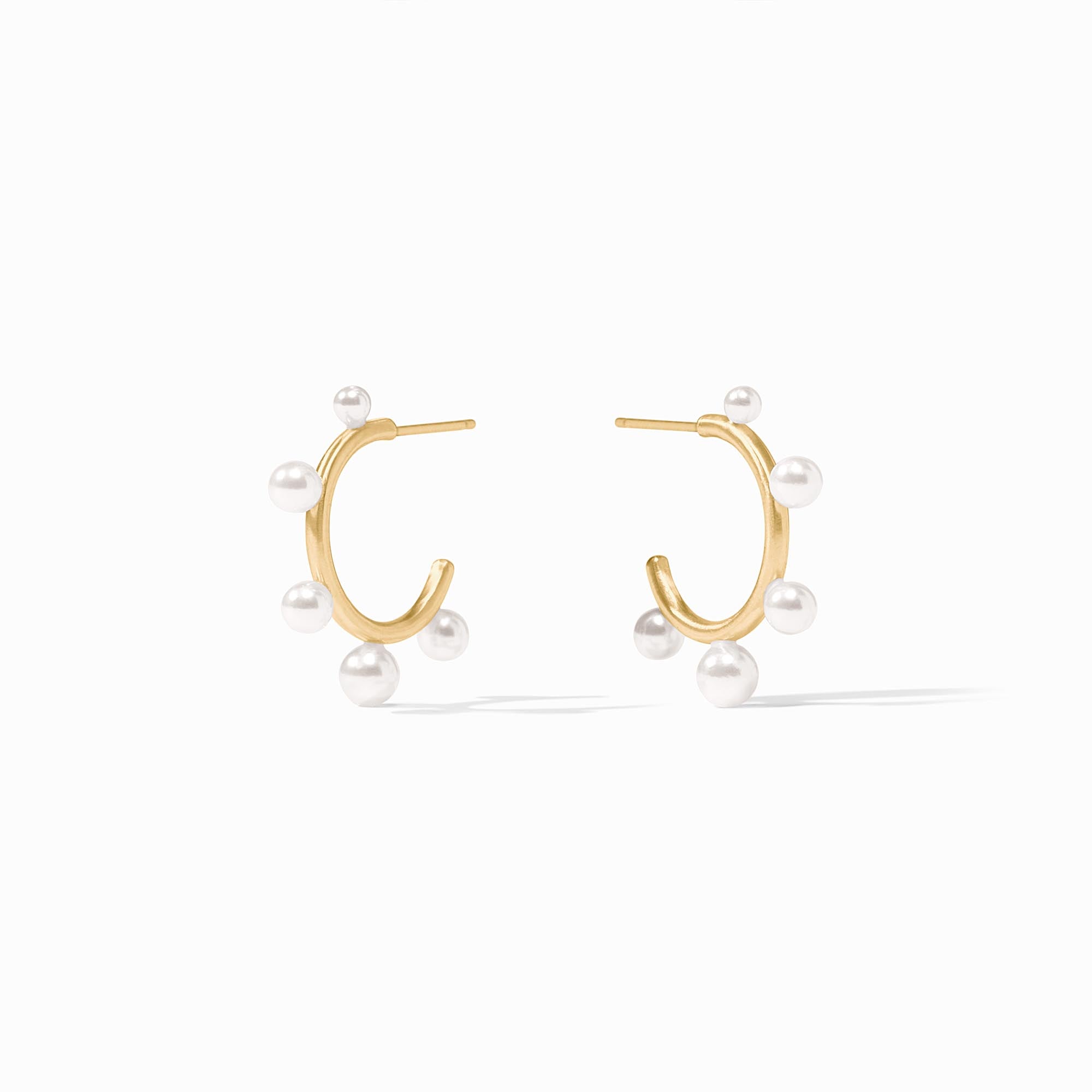 Slender golden hoop earrings with small shell pearls and gumdrop-like gemstones.