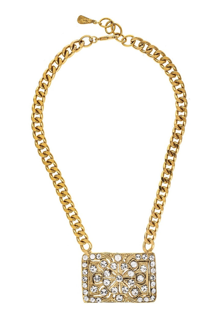 Gold curb-link chain necklace with a rectangular pendant featuring crystals and etched details.