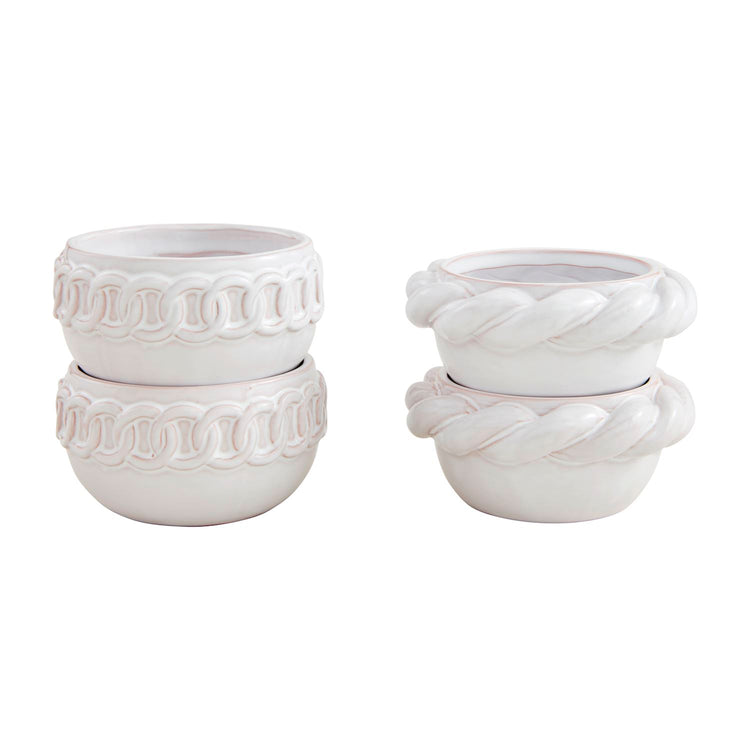 Two stacks of white ceramic tidbit bowls with decorative chain and rope textured rims.