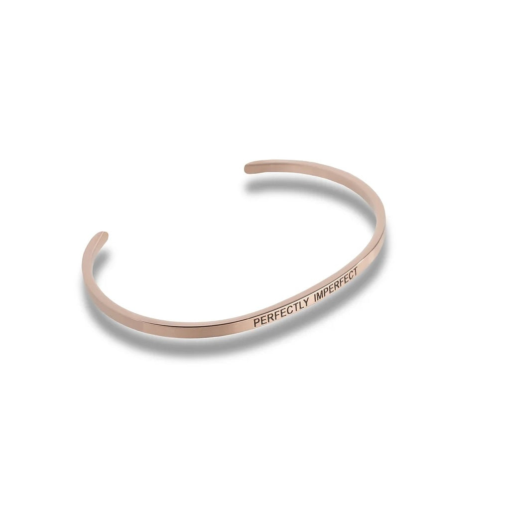 Rose gold cuff bracelet with the engraved text PERFECTLY IMPERFECT.