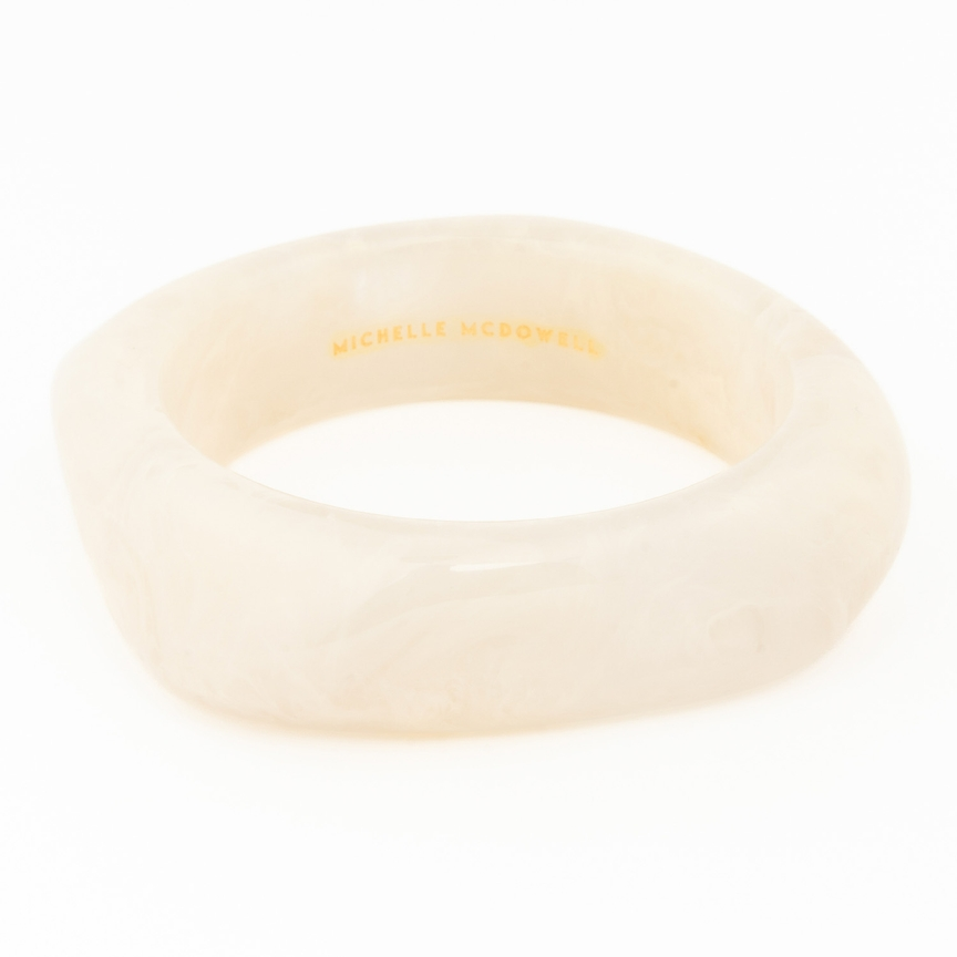 Cream-colored marbled resin Tillie Bangle with Michelle McDowell branding on the interior.