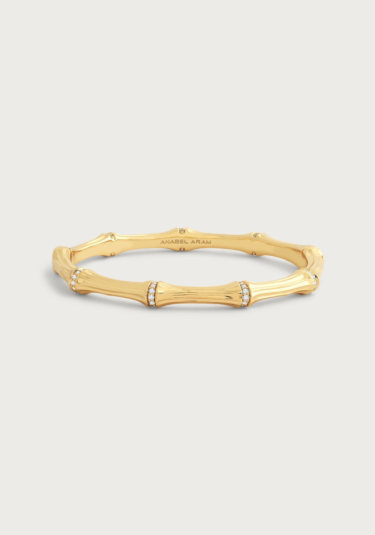 Gold-plated bamboo-shaped hinged bangle with crystal pavé accents on each segment.