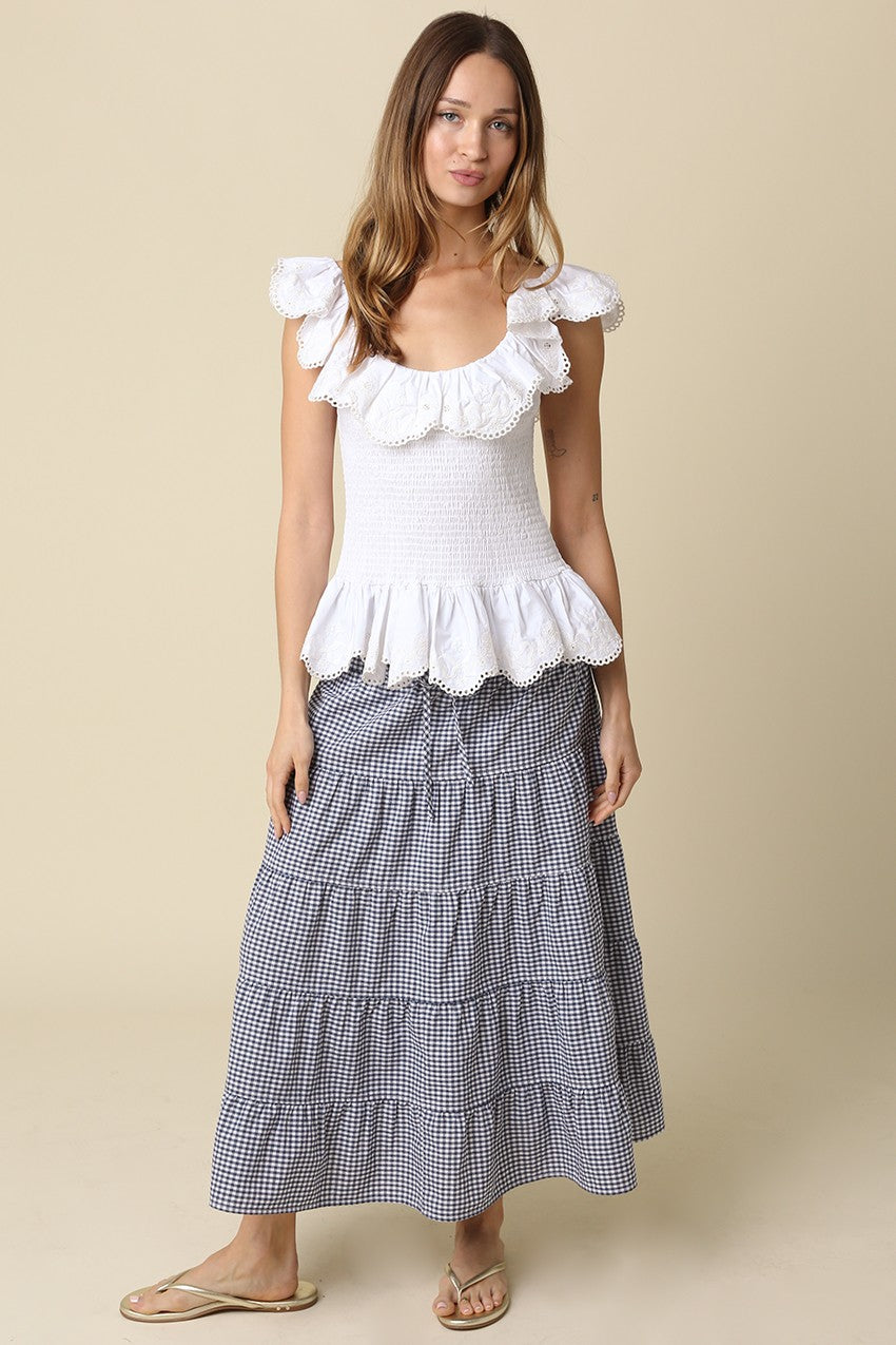 Woman wearing a Jasmine Gingham Drawstring Tiered Maxi Skirt in navy and white with a white top.