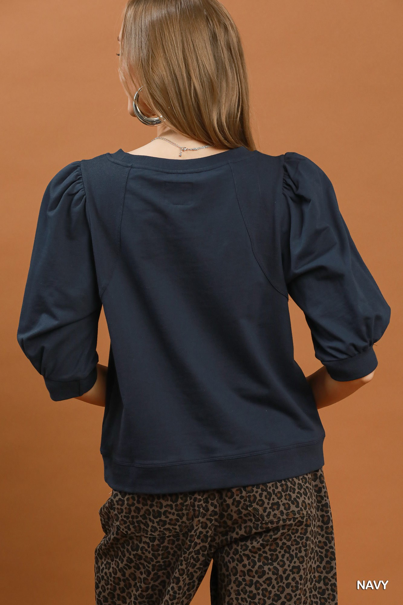 Back view of a navy blue Joyce Puff Sleeve Pullover Sweatshirt with ribbed cuffs and hem.