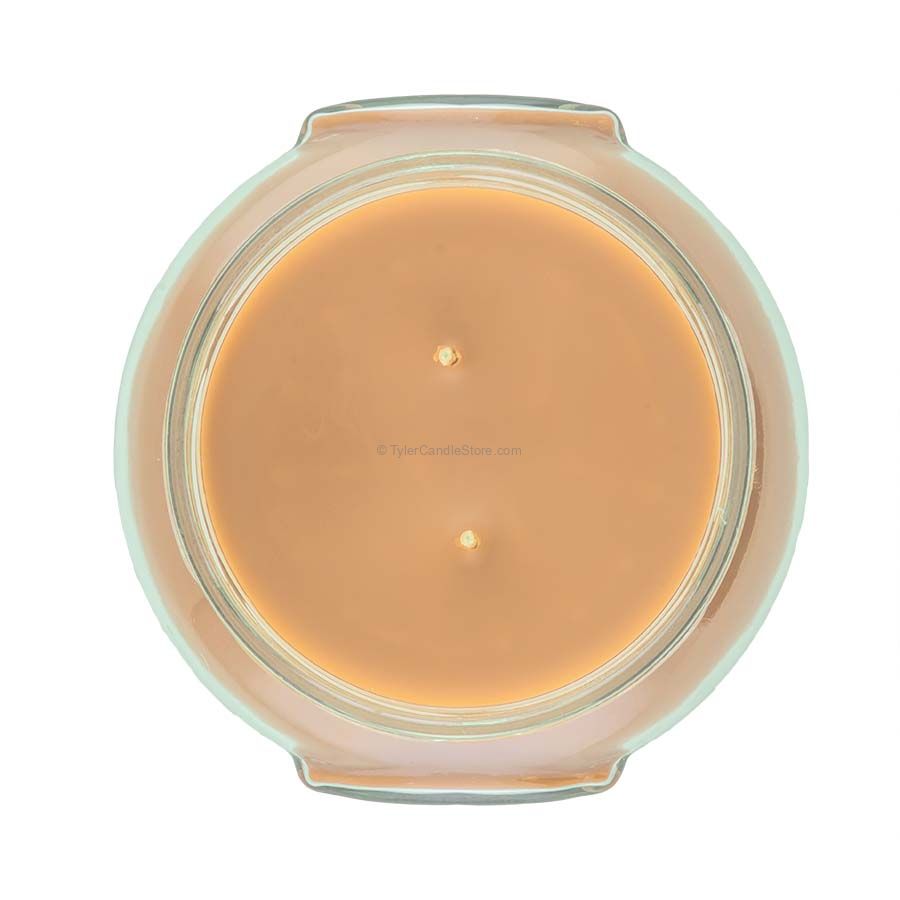 A large black glass jar containing a white candle with the label Tyler Candle.