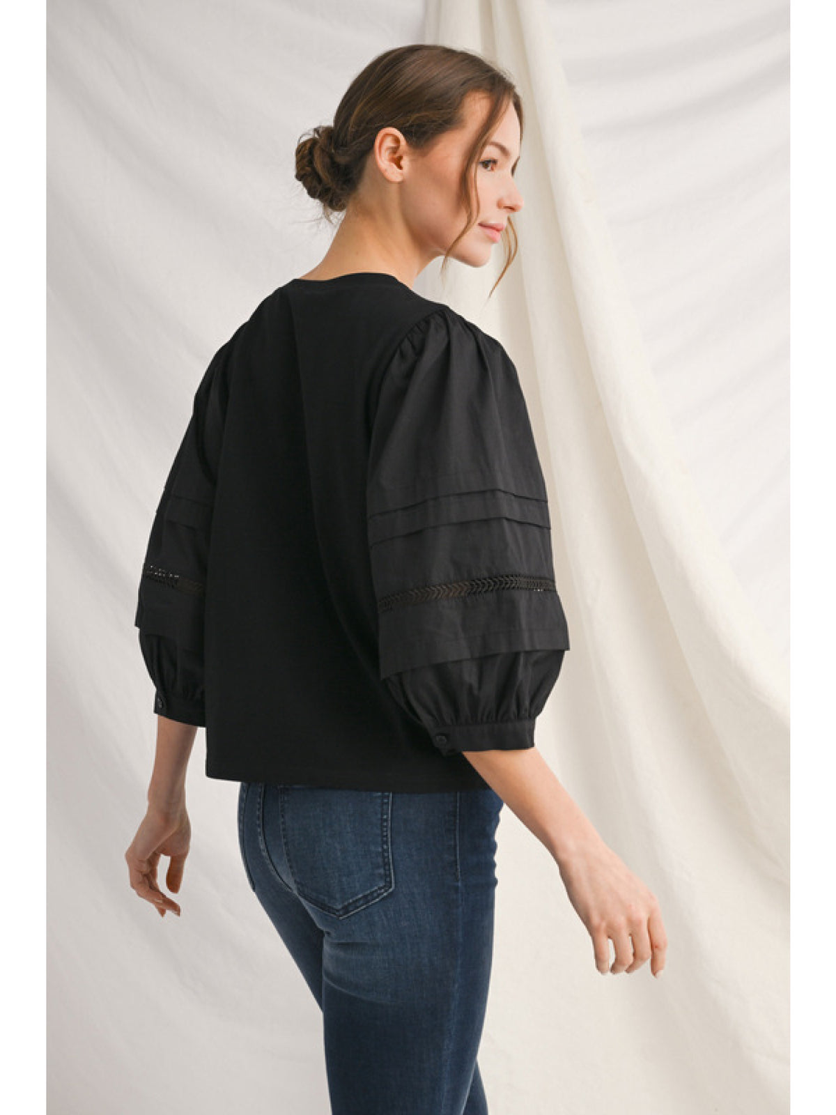 Alice solid top with ladder lace trim at neckline and button closure cuffs.