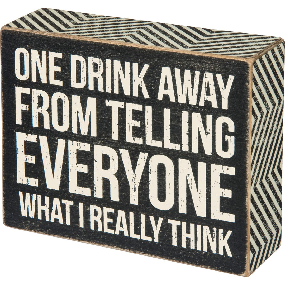 Black wooden box sign with white text reading "ONE DRINK AWAY FROM TELLING EVERYONE WHAT I REALLY THINK".