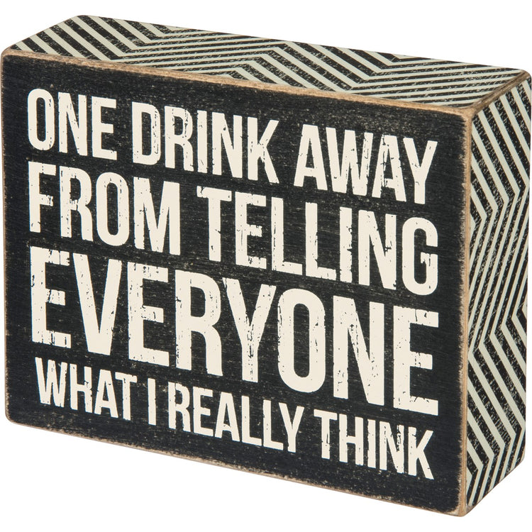 Black wooden box sign with white text reading "ONE DRINK AWAY FROM TELLING EVERYONE WHAT I REALLY THINK".