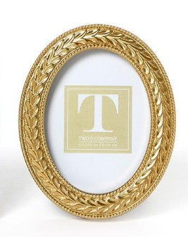 Oval gold photo frame with an intricate laurel wreath design and beaded edges.