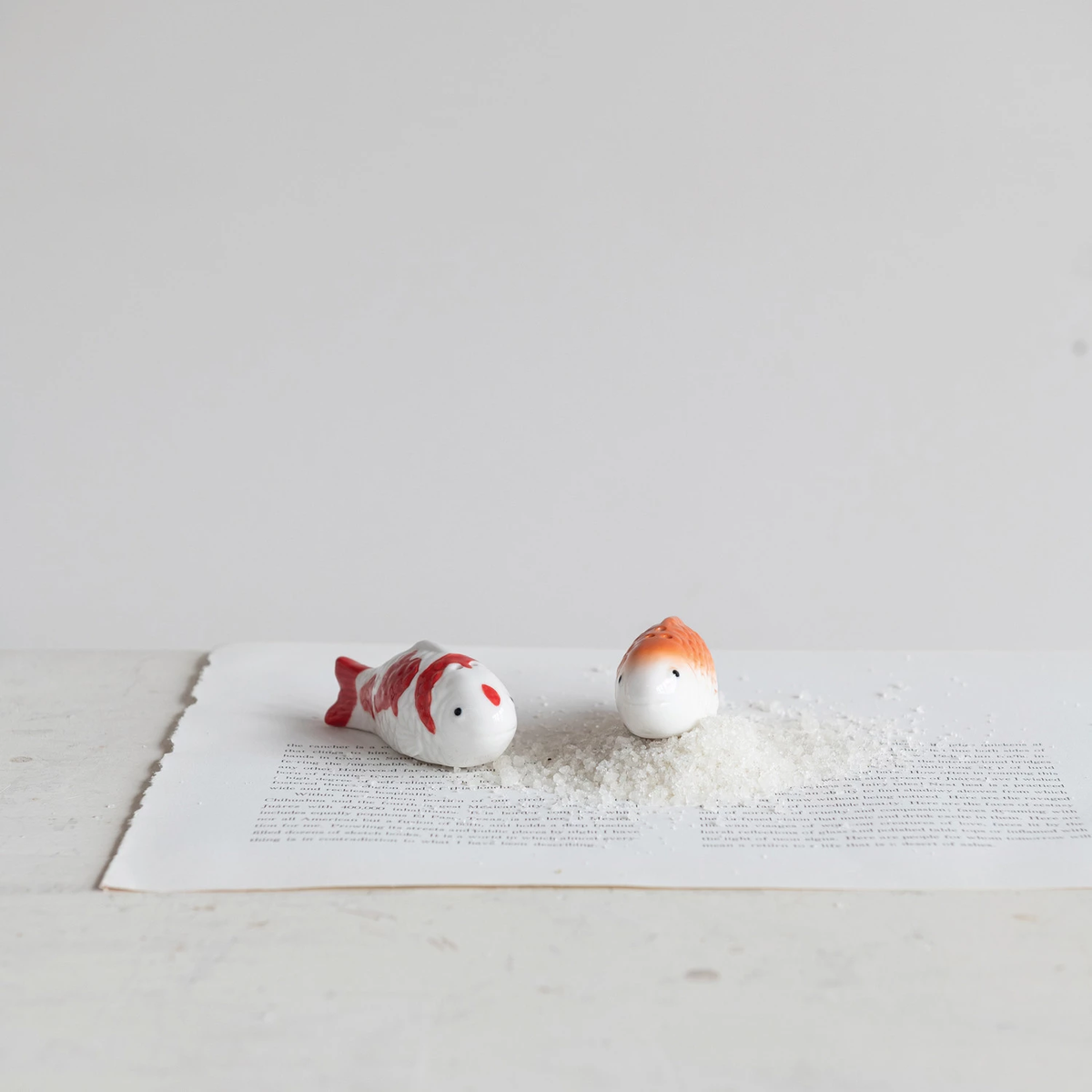 Set of two stoneware koi fish salt and pepper shakers in white with red and orange details.