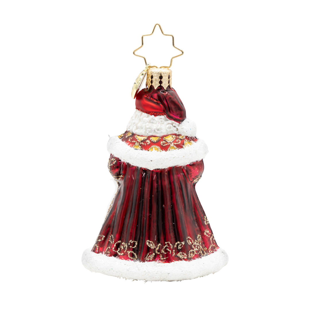 Back view of a Santa glass ornament in a satin red coat with gold glitter patterns and white trim.
