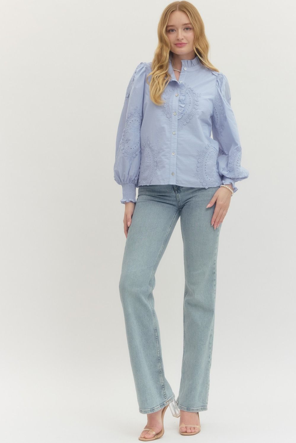 Woman wearing the Avery Solid Long Sleeve Button Front Top in light blue with light wash jeans.